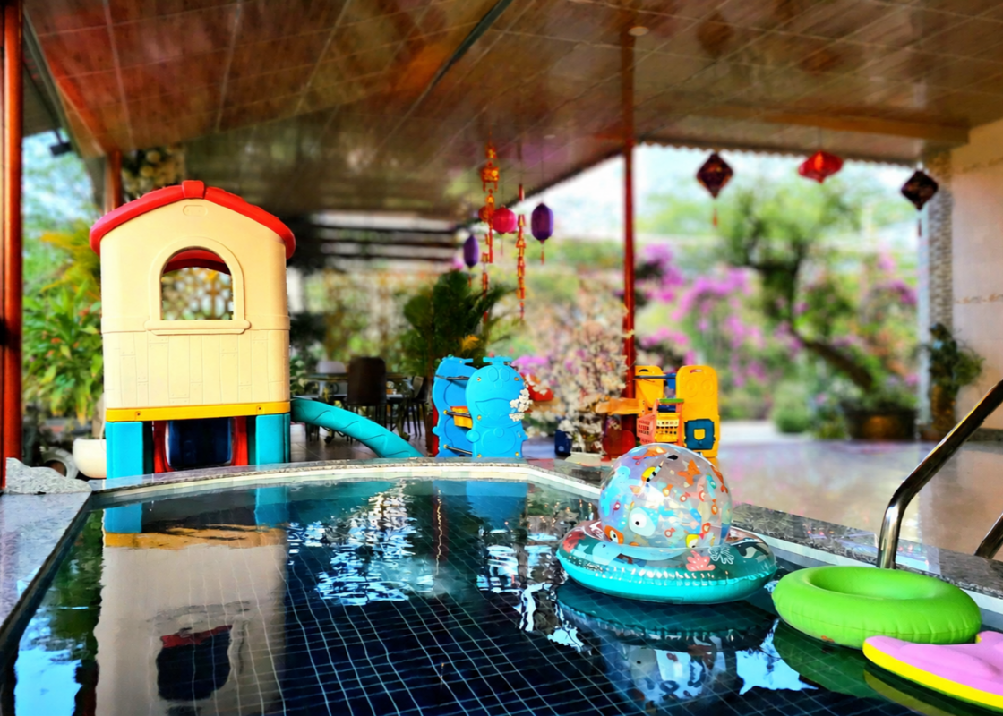 Hồ bơi cho trẻ dưới 16 tuổi tại sala ho tram homestay & Villa. Làn nước hồ bơi xanh mát có phao bơi sắc màu bên cạnh góc vui chơi cho trẻ em trong khuôn viên sân vườn, gần biển Hồ Tràm.
