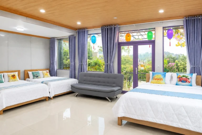 Phòng 3 giường đôi tại Sala Ho Tram Homestay & Villa Hồ Tràm với cửa kính lớn, ban công và tầm nhìn ra khu vườn xanh, phù hợp cho gia đình hoặc nhóm bạn.